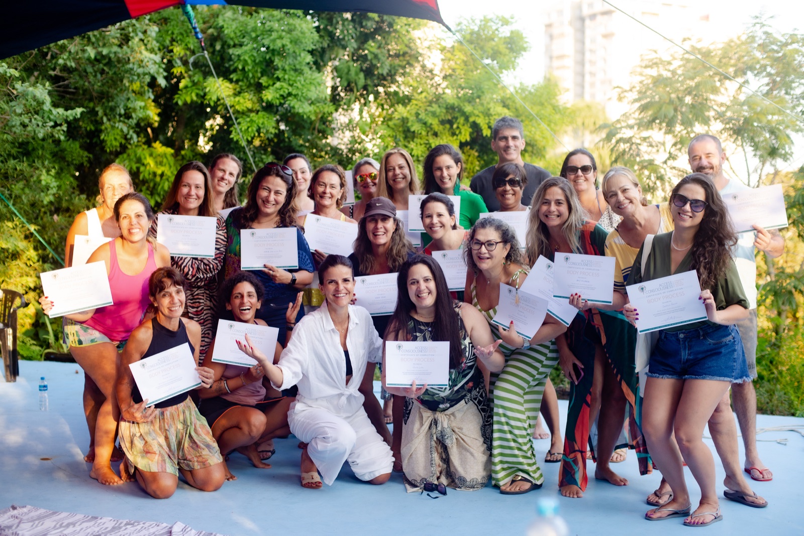 Turma certificada da Classe de Barras celebrando com os certificados, com a Adriana ao centro